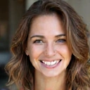 Uśmiechnięta kobieta w średnim wieku, z energią i pogodą ducha, symbolizująca sukces w zdrowiu.